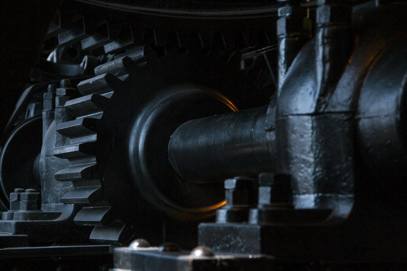 Close view of dark interlocking metal gears, with no people in the frame.